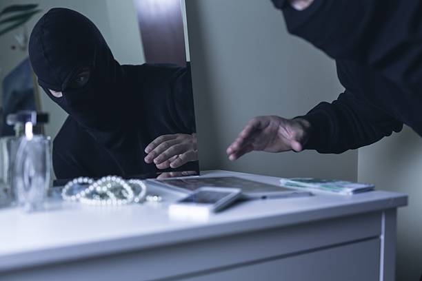 Masked intruder during robbery Photo of masked intruder during robbery in villa vacation rental mask stock pictures, royalty-free photos & images