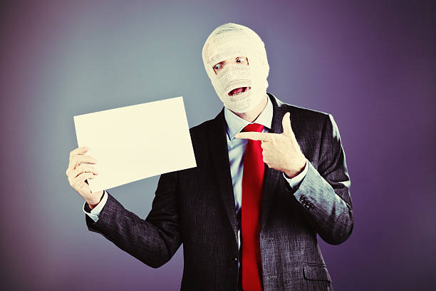 istock Bandaged businessman points out blank sign, ready for your merssage 510491625
