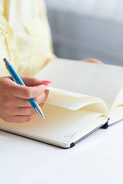 istock Young woman writes to black diary 510491779