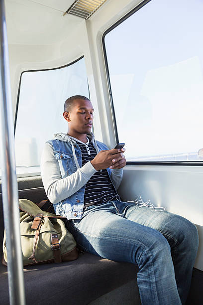 istock Young man riding tram, texting 510492137