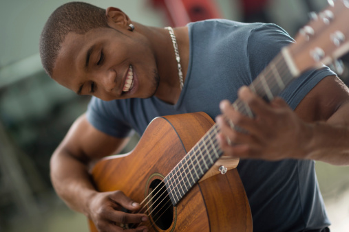 Young teenager playing guitar and recording vlog and music tutorial for the Internet.