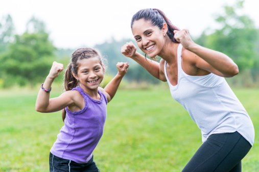 Mother and daughter doing exercises outdoors