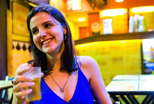 Young girl drinking beer in a bar at Rio de Janeiro.