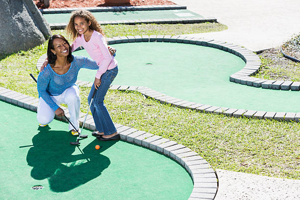 matka i dziecko gra minigolf - standing family golf loving zdjęcia i obrazy z banku zdjęć