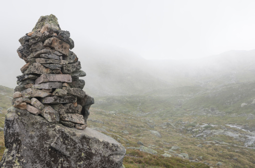 Cairn of rocks leads the way in foggy weather