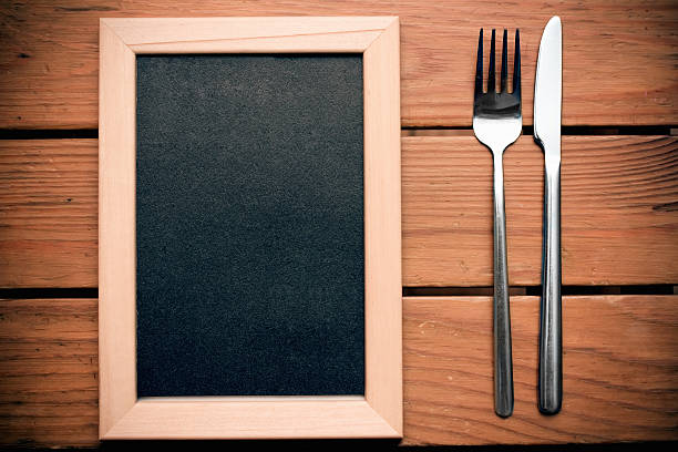 istock Black chalkboard for menu with silver knife and fork 510534051