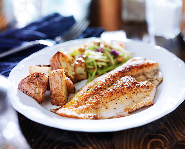 pan fried tilapia with asian slaw and roasted potatoes pan fried tilapia with asian slaw and roasted potatoes shot with selective focus crockery stock pictures, royalty-free photos & images