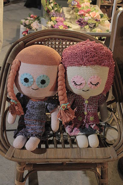 istock two girl doll sit together on chair 510537653