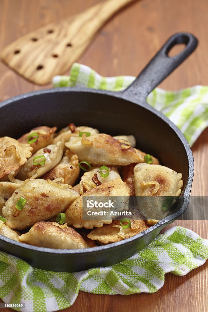 Dumplings fried with onion Homemade dumplings fried with onion on a pan Appetizer Stock Photo