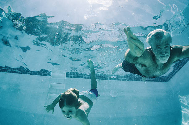 nonno e nipote nuoto sott'acqua in estate - swimming pool swimming summer underwater foto e immagini stock