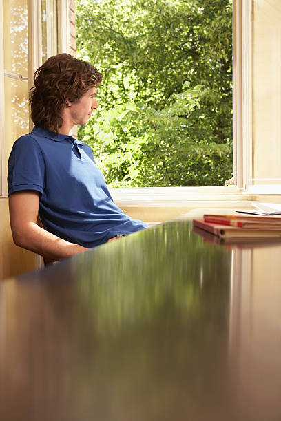 istock Man Looking Out Of Window In Study Room 510562645