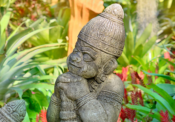 Stone sculptures of men striking plants in the park