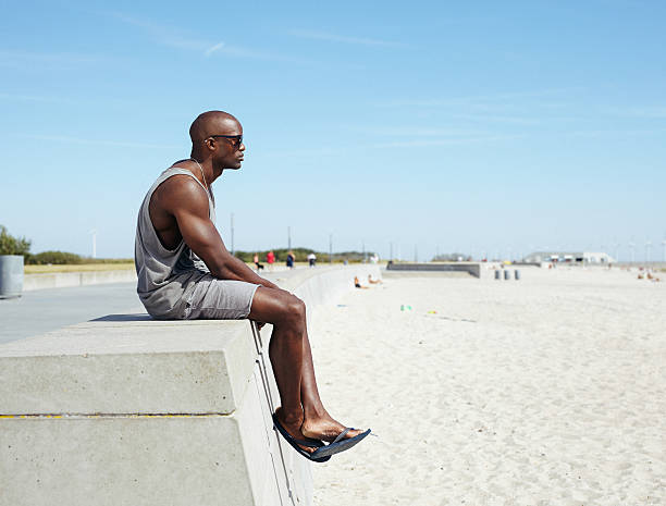 African man sitting on a beach promenade