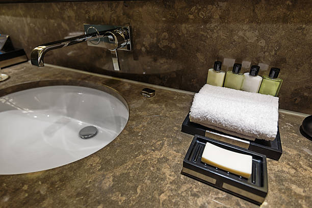 hotel bathroom detail with soap, towel and shampoo - hotel shampoo stockfoto's en -beelden