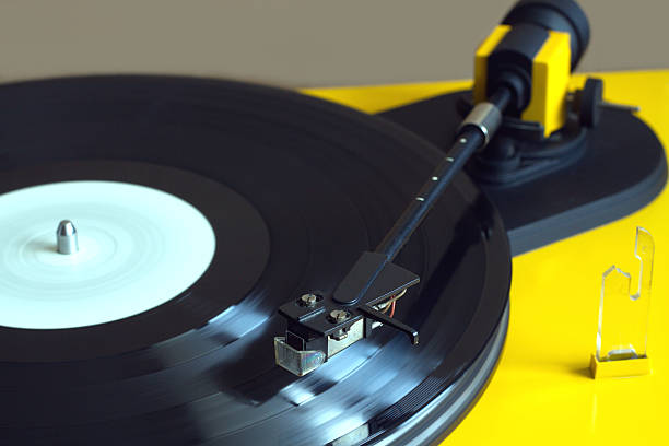 istock Yellow turntable plays vinyl record closeup 510565336