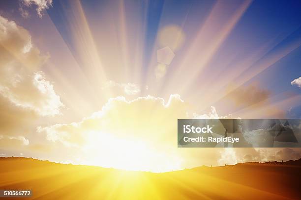 The Suns Rays On The Horizon Flare Dramatically Through Clouds Stock Photo - Download Image Now