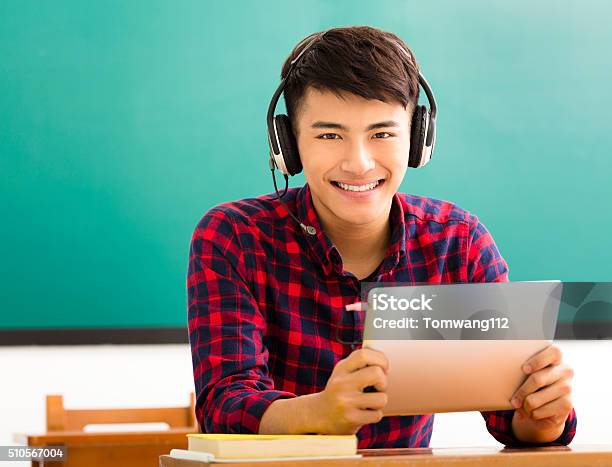Happy Student Reading Tablet In Classroom Stock Photo - Download Image Now - Headphones, Asian and Indian Ethnicities, Boys