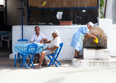 Santorini, Greece - October 2, 2010: diners sit in a traditional Greek restaurant during summertime in the city center of Santorini island.