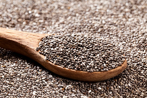 Wooden spoon with chia seeds Wooden spoon with chia seeds. DSRL studio photo taken with Canon EOS 5D Mk II and Canon EF 100mm f/2.8L Macro IS USM CHIA SEEDS stock pictures, royalty-free photos & images
