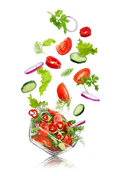 Photo of glass salad bowl in flight with vegetables