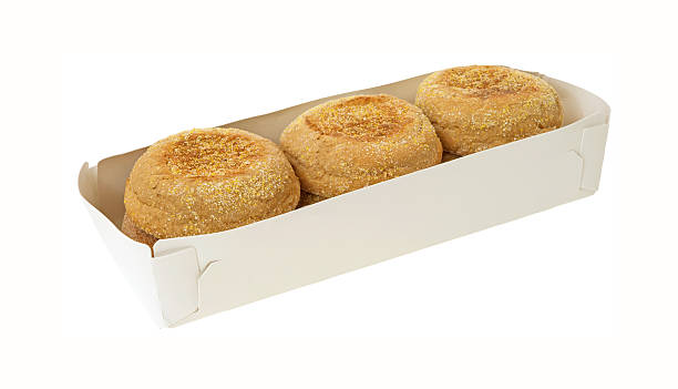 Whole wheat muffins in packaging Several fresh organic whole wheat muffins in the paper packaging on a white background. english muffin stock pictures, royalty-free photos & images