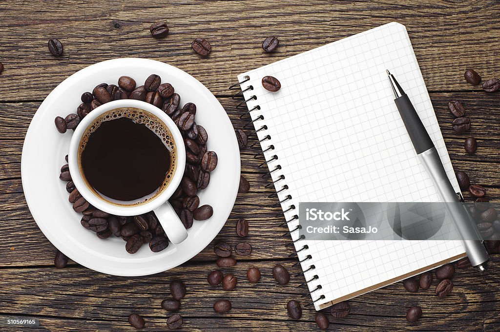 Coffee and notepad Cup of coffee, pen and opened notepad on desk. Top view Backgrounds Stock Photo