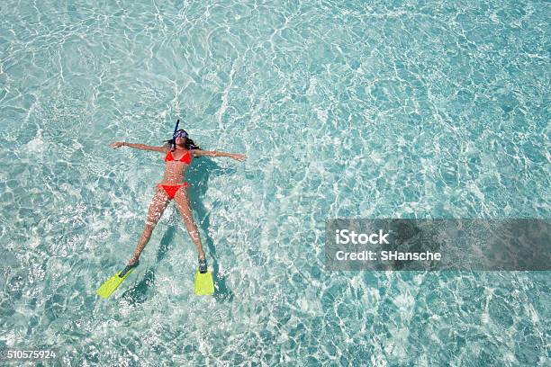 Woman Floating On Crystal Clear Waters Stock Photo - Download Image Now - Maldives, Snorkeling, Diving Into Water