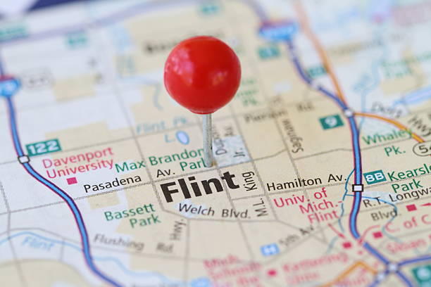 Macro shot of push pin on map of Flint MIchigan Macro shot of red push pin on map of Flint, MIchigan. flint michigan stock pictures, royalty-free photos & images