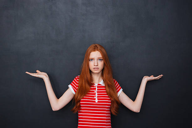 istock Confused woman holding copyspace on both palms over chalkboard background 510578852