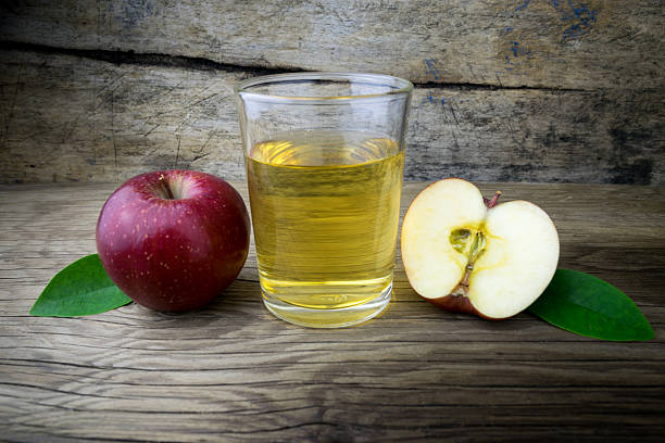 istock Apple juice and apples on a wooden table 510582020