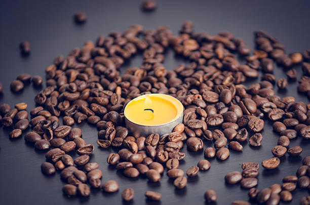 istock Coffee beans on a black background with candle. 510584318