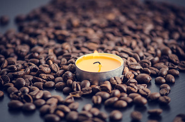 istock Coffee beans on a black background with candle. 510584364