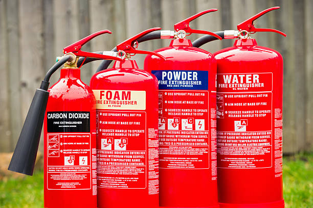 Fire extinguishers: Carbon dioxide, Foam, Powder and Water A grouping of carbon dioxide, foam, powder and water fire extinguishers in a row. fire extinguisher photos stock pictures, royalty-free photos & images