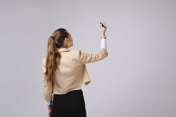 istock young woman with pen on grey background 510586678