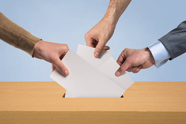 Vote Hands inserting a blank vote suggestion box stock pictures, royalty-free photos & images