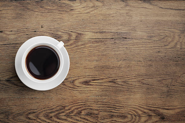 istock Black coffee cup on old wooden table top view 510587644