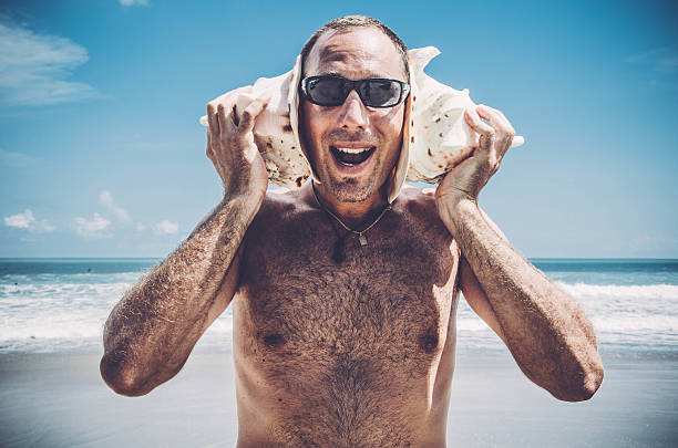 istock Man listening to Sea Shells 510587926