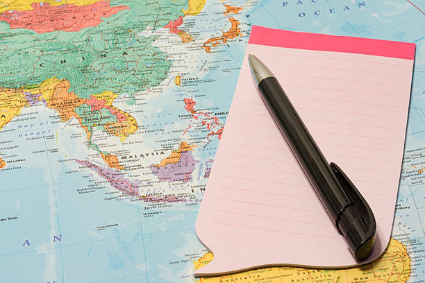 istock Pink notepad and pen on top of map 510588138