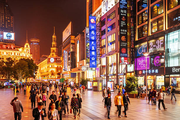 Shoppping Street in Shanghai, China Crowds walk below neon signs on Nanjing Road. The street is the main shopping district of the city and one of the world's busiest shopping districts.  jiangsu province photos stock pictures, royalty-free photos & images