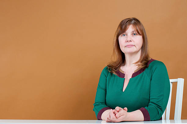 Cute woman sitting at a table. stock photo