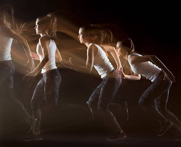 Female Athlete Practicing motion patterns on black background Side view of young woman athlete running and jumping on black background, real athlete, Stroboscopic Image temporal aliasing stock pictures, royalty-free photos & images