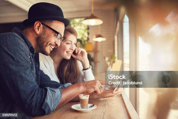 Photo libre de droit de Couple À Laide Dune Tablette Numérique Dans Un Café banque d'images et plus d'images libres de droit de Amitié