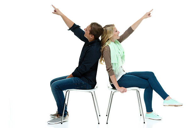 Couple sitting on chair and pointing away