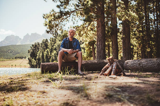 istock Mature man sitting on a log staring out the lake 510610476