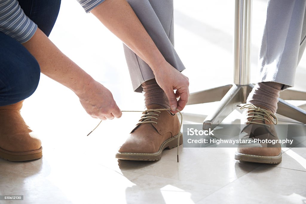 Fille adulte aider Senior de serrage lacets - Photo de Assistance libre de droits