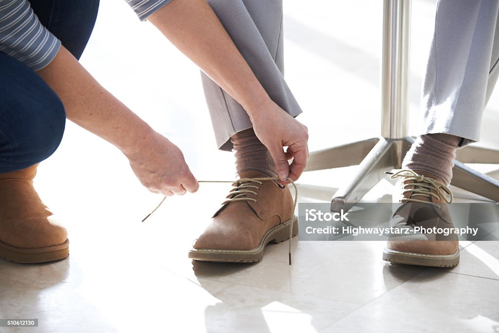 Adult Daughter Helping Senior Tie Shoelaces Assistance Stock Photo