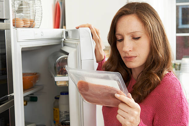 Concerned Woman Looking At Pre Packaged Meat Concerned Woman Looking At Pre Packaged Meat rotting stock pictures, royalty-free photos & images