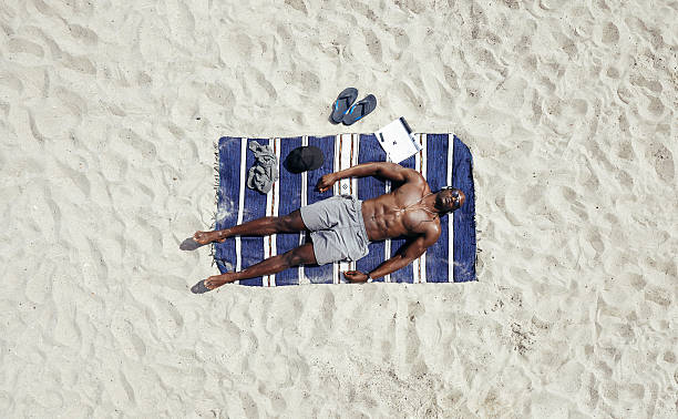 afrykański mężczyzna model opalać się - men sleeping african descent shoe zdjęcia i obrazy z banku zdjęć