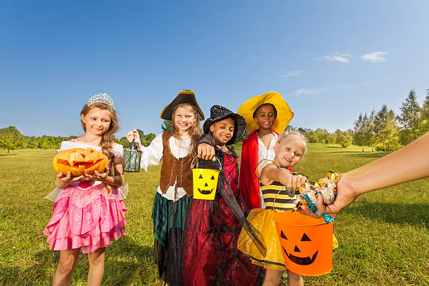 istock Children in costumes look at hand with sweets 510613301