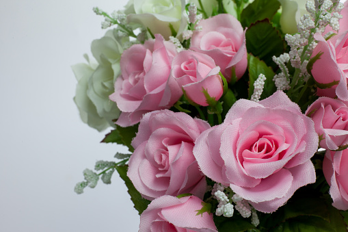 A beautiful bouquet with roses and white alstroemeria against a white wall